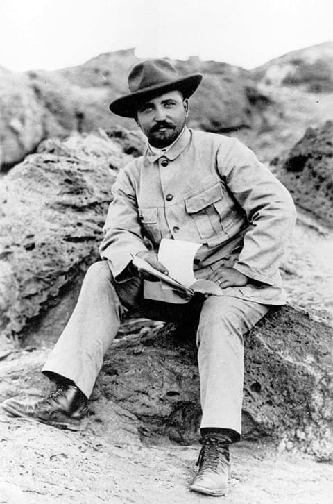 August Stauch, Porträt auf einem Felsen sitzend